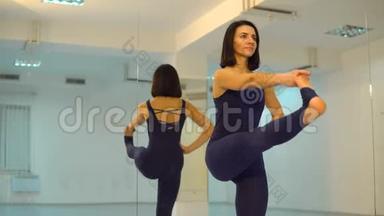 年轻伸展的女人做瑜伽姿势和体式。 漂亮的女人穿着运动服在室内享受瑜伽